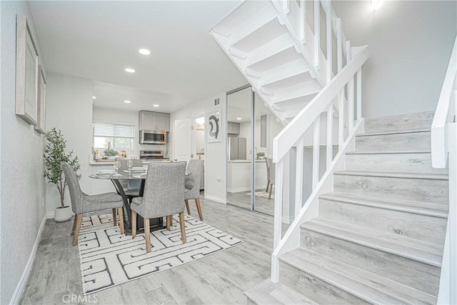 15300 Ocaso Ave Unit E102, La Mirada, CA 90638 - dining area with stairs, light wood-style floors, and recessed lighting