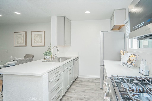 15300 Ocaso Ave Unit E102, La Mirada, CA 90638 - kitchen featuring appliances with stainless steel finishes, light wood-type flooring, recessed lighting, light countertops, and a peninsula