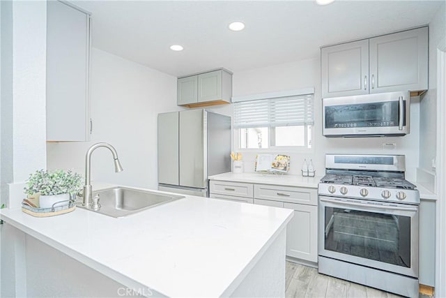 15300 Ocaso Ave Unit E102, La Mirada, CA 90638 - kitchen with stainless steel appliances, light countertops, light wood-style floors, recessed lighting, and a peninsula
