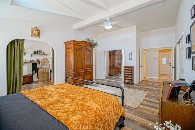 1001 Gibralter Rd, Landers, CA 92285 - bedroom featuring wood finished floors, beam ceiling, arched walkways, and ceiling fan