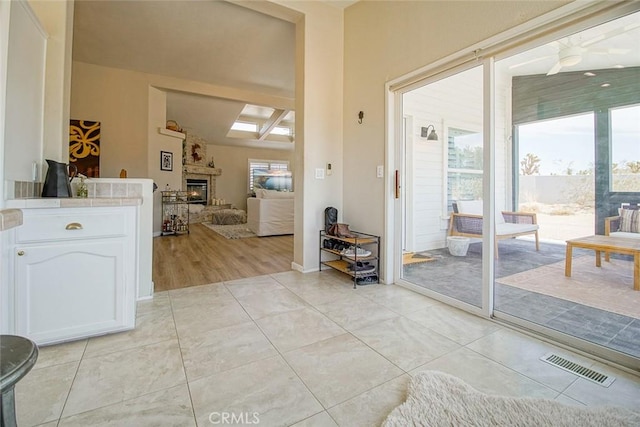 1001 Gibralter Rd, Landers, CA 92285 - foyer entrance with a glass covered fireplace, a skylight, and light tile patterned floors