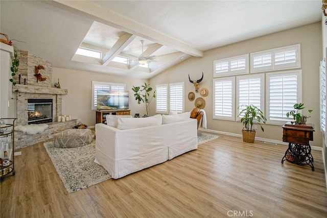 1001 Gibralter Rd, Landers, CA 92285 - living area with ceiling fan, wood finished floors, a stone fireplace, and a skylight