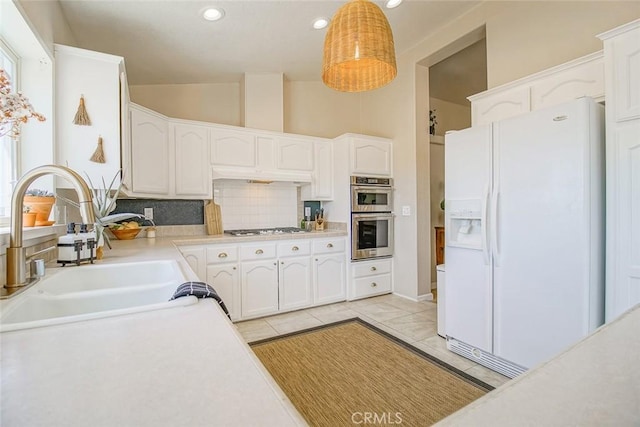 1001 Gibralter Rd, Landers, CA 92285 - kitchen featuring appliances with stainless steel finishes, tasteful backsplash, white cabinets, vaulted ceiling, and recessed lighting