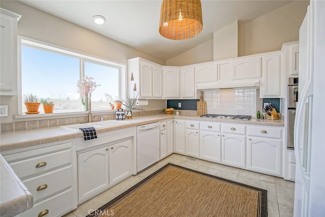 1001 Gibralter Rd, Landers, CA 92285 - kitchen featuring white dishwasher, vaulted ceiling, gas cooktop, light tile patterned flooring, and white cabinets