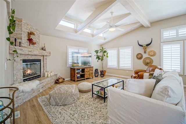 1001 Gibralter Rd, Landers, CA 92285 - living area featuring a skylight, a ceiling fan, wood finished floors, and a stone fireplace