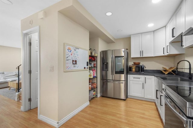 1450 Melrose Ave Unit 31, Chula Vista, CA 91911 - kitchen featuring appliances with stainless steel finishes, dark countertops, white cabinets, light wood-style floors, and recessed lighting