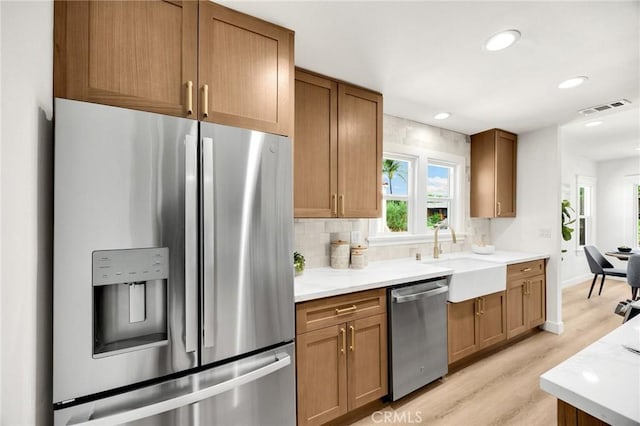 5336 Stratford Rd, Los Angeles, CA 90042 - kitchen with stainless steel appliances, light wood-type flooring, decorative backsplash, recessed lighting, and brown cabinets