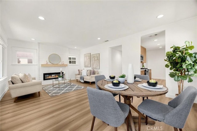 5336 Stratford Rd, Los Angeles, CA 90042 - dining space featuring light wood-style flooring, a large fireplace, and recessed lighting