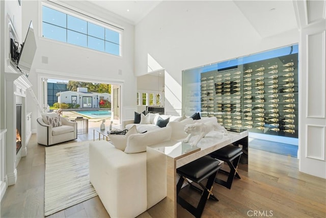 17528 Jayden Ln, Encino, CA 91316 - living room with a towering ceiling, a lit fireplace, and wood finished floors