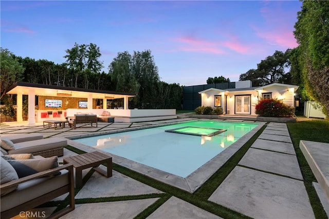 17528 Jayden Ln, Encino, CA 91316 - pool at dusk featuring a hot tub, an exterior structure, an outdoor living space, a patio, and an outbuilding
