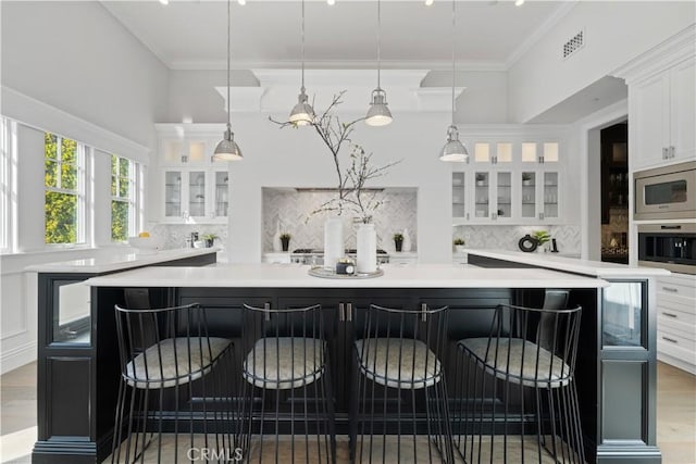 17528 Jayden Ln, Encino, CA 91316 - kitchen featuring appliances with stainless steel finishes, white cabinetry, decorative backsplash, light countertops, and ornamental molding
