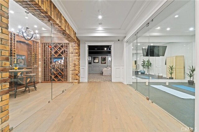 17528 Jayden Ln, Encino, CA 91316 - wine cellar with wood-type flooring, a chandelier, a decorative wall, ornamental molding, and a wainscoted wall