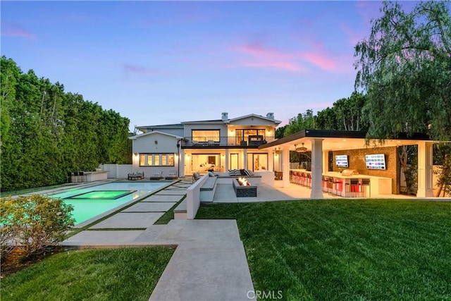17528 Jayden Ln, Encino, CA 91316 - back of house at dusk featuring a patio area, a balcony, a fire pit, and an outdoor pool