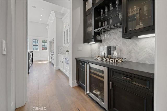 17528 Jayden Ln, Encino, CA 91316 - indoor dry bar featuring beverage cooler, ornamental molding, wood finished floors, and backsplash