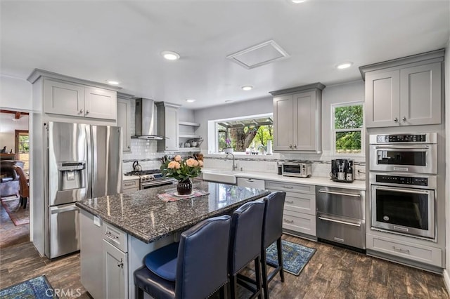 5729 Grandview Ave, Yorba Linda, CA 92886 - kitchen with wall chimney range hood, appliances with stainless steel finishes, tasteful backsplash, gray cabinetry, and a breakfast bar