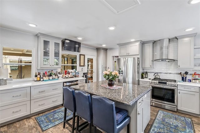 5729 Grandview Ave, Yorba Linda, CA 92886 - kitchen with appliances with stainless steel finishes, wall chimney range hood, a kitchen breakfast bar, a center island, and dark wood finished floors