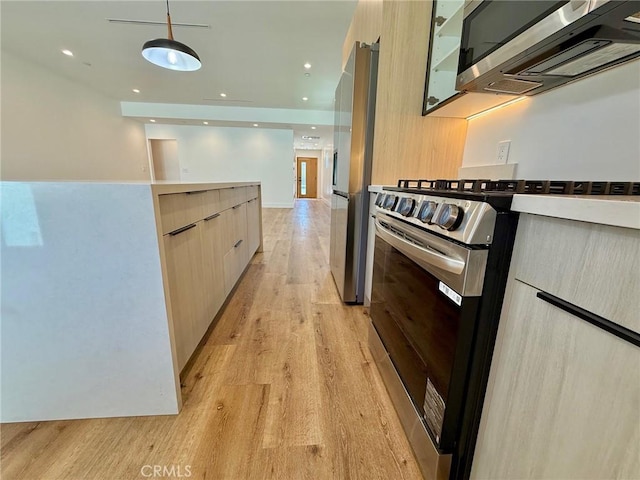 6904 Corbin Ave, Reseda, CA 91335 - kitchen with modern cabinets, appliances with stainless steel finishes, light wood-style flooring, decorative light fixtures, and light countertops