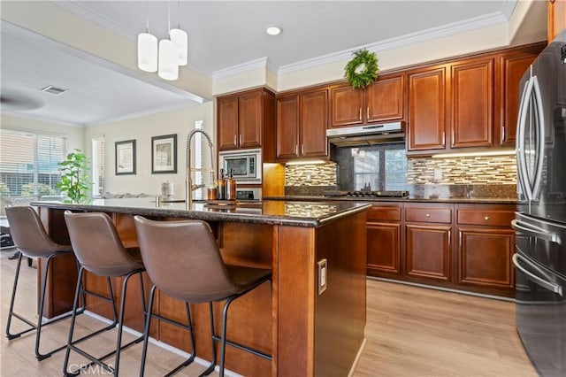 28549 Oakhurst Way, Temecula, CA 92591 - kitchen featuring under cabinet range hood, appliances with stainless steel finishes, a kitchen breakfast bar, backsplash, and crown molding