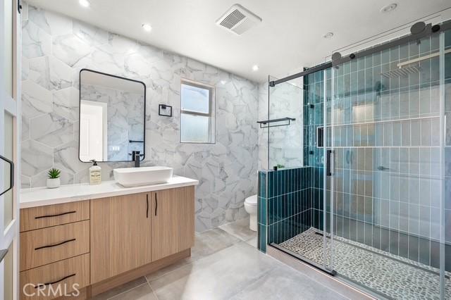 647 Magnolia Ave, Brea, CA 92821 - full bath featuring vanity, a shower stall, marble finish floors, and tile walls
