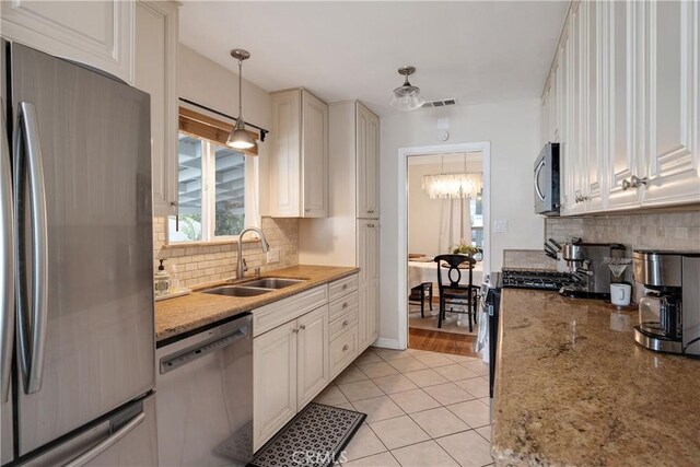 20108 Wayne Ave, Torrance, CA 90503 - kitchen featuring stainless steel appliances, backsplash, light tile patterned floors, hanging light fixtures, and white cabinets