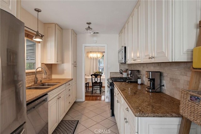 20108 Wayne Ave, Torrance, CA 90503 - kitchen with stainless steel appliances, tasteful backsplash, light tile patterned floors, a chandelier, and hanging light fixtures