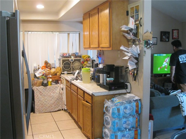 235 E 7th St, San Jacinto, CA 92583 - kitchen featuring freestanding refrigerator, light tile patterned flooring, light countertops, and brown cabinets
