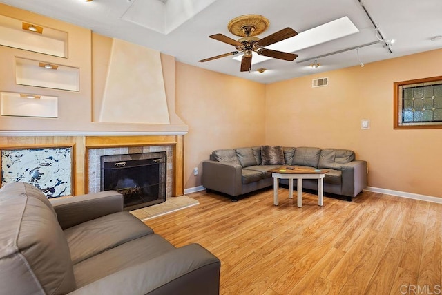 10048 Waynecrest Ln, Santee, CA 92071 - living room with rail lighting, light wood-style floors, ceiling fan, and a fireplace