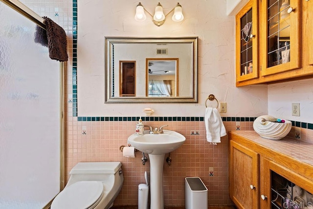 10048 Waynecrest Ln, Santee, CA 92071 - bathroom featuring tile walls, wainscoting, and a shower