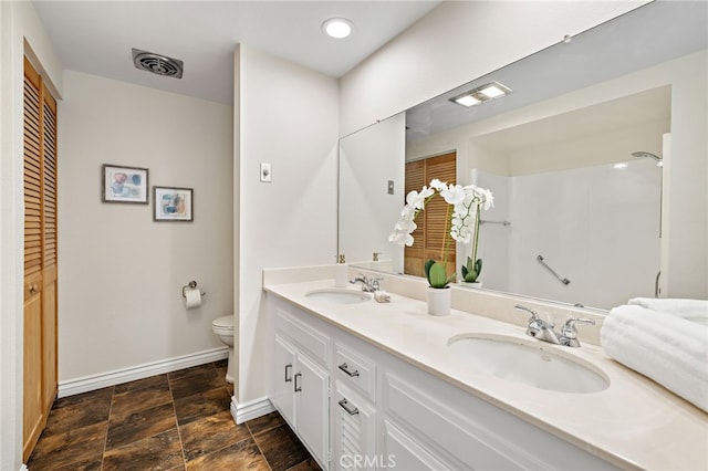 2133 Via Puerta Unit A, Laguna Woods, CA 92637 - bathroom with double vanity, stone finish floors, a closet, and a shower