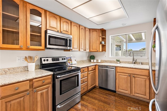 2133 Via Puerta Unit A, Laguna Woods, CA 92637 - kitchen featuring appliances with stainless steel finishes, dark wood finished floors, glass insert cabinets, light stone countertops, and brown cabinets