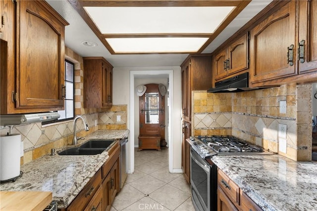 320 Casa Real Pl, Nipomo, CA 93444 - kitchen featuring stainless steel gas range, under cabinet range hood, brown cabinets, and tasteful backsplash