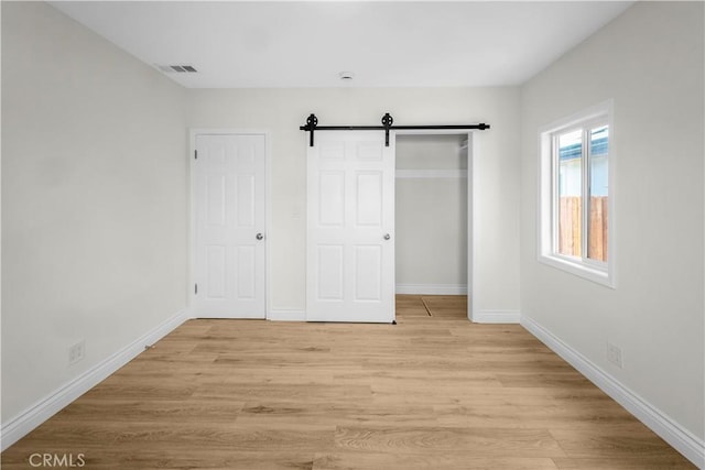 4251 Gundry Ave, Long Beach, CA 90807 - unfurnished bedroom featuring light wood-style flooring, a closet, and a barn door