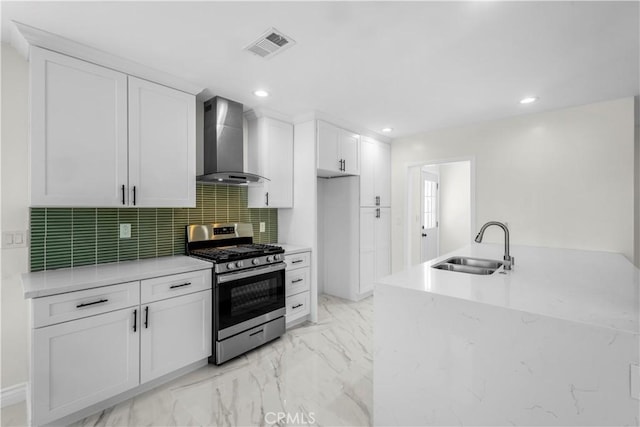 4251 Gundry Ave, Long Beach, CA 90807 - kitchen with wall chimney range hood, stainless steel range with gas stovetop, white cabinetry, light marble finish floors, and recessed lighting