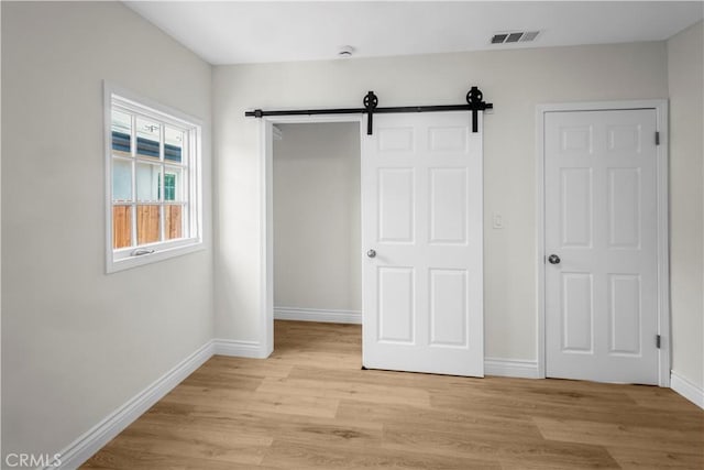4251 Gundry Ave, Long Beach, CA 90807 - unfurnished bedroom featuring light wood-type flooring, a barn door, and a closet