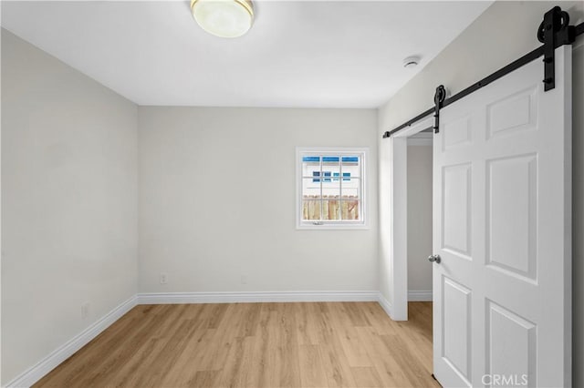 4251 Gundry Ave, Long Beach, CA 90807 - unfurnished bedroom featuring a barn door and light wood-style floors