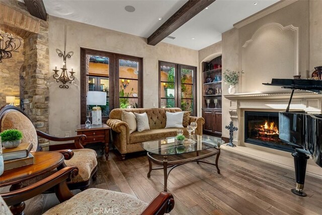 25492 Spotted Pony Ln, Laguna Hills, CA 92653 - sitting room with wood-type flooring, built in shelves, beam ceiling, and a glass covered fireplace