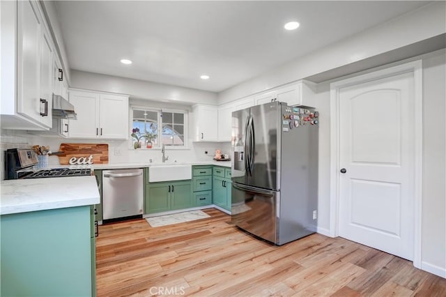 1276 Sao Paulo Ave, Placentia, CA 92870 - kitchen with appliances with stainless steel finishes, under cabinet range hood, light wood-style floors, white cabinets, and recessed lighting