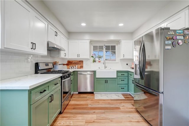 1276 Sao Paulo Ave, Placentia, CA 92870 - kitchen with appliances with stainless steel finishes, green cabinetry, under cabinet range hood, white cabinets, and light wood finished floors