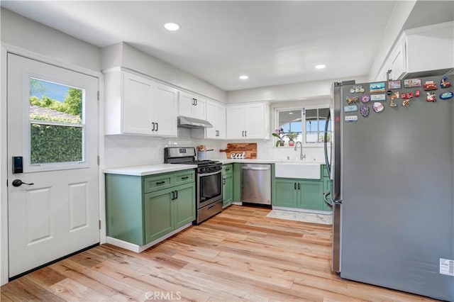 1276 Sao Paulo Ave, Placentia, CA 92870 - kitchen with appliances with stainless steel finishes, green cabinetry, under cabinet range hood, white cabinetry, and light wood finished floors