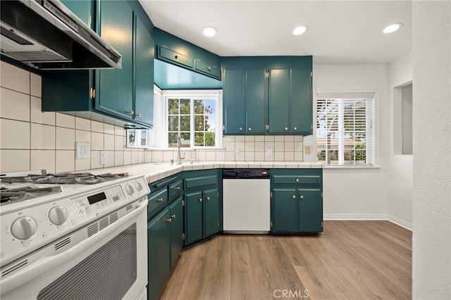 2871 Adriatic Ave, Long Beach, CA 90810 - kitchen featuring white appliances, under cabinet range hood, light wood-style flooring, backsplash, and recessed lighting