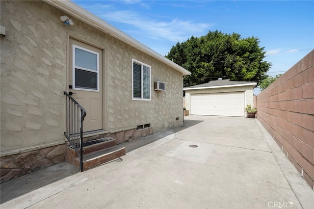 2871 Adriatic Ave, Long Beach, CA 90810 - view of side of home with entry steps, a wall mounted AC, an outdoor structure, stucco siding, and a detached garage