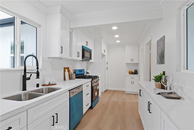 14867 Roxton Ave, Gardena, CA 90249 - kitchen with dishwashing machine, stainless steel range with gas cooktop, light countertops, light wood-type flooring, and white cabinetry