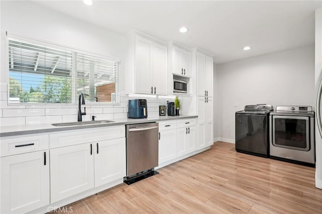 20042 Lassen St, Chatsworth, CA 91311 - kitchen with stainless steel appliances, washer and dryer, decorative backsplash, white cabinetry, and recessed lighting