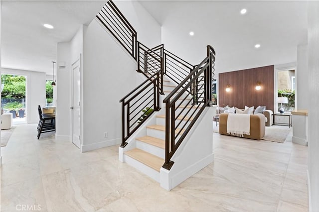 15 Glastonbury Pl, Laguna Niguel, CA 92677 - stairs featuring marble finish floors, wooden walls, and recessed lighting