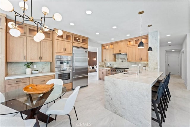 15 Glastonbury Pl, Laguna Niguel, CA 92677 - kitchen with stainless steel appliances, a peninsula, tasteful backsplash, a kitchen bar, and glass insert cabinets