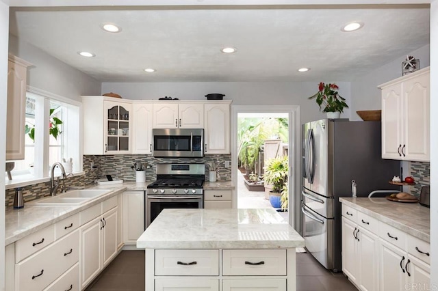 121 Cadmus St, Encinitas, CA 92024 - kitchen featuring appliances with stainless steel finishes, tasteful backsplash, glass insert cabinets, white cabinetry, and a center island