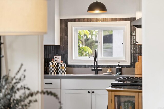 216466 S 40th St, San Diego, CA 92113 - kitchen with white cabinetry, dark countertops, hanging light fixtures, and decorative backsplash