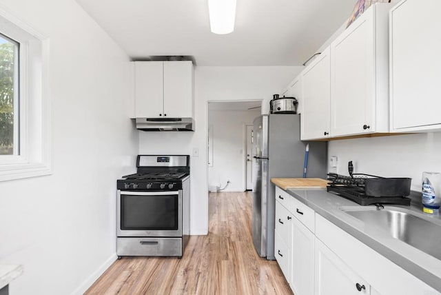 216466 S 40th St, San Diego, CA 92113 - kitchen featuring stainless steel range with gas stovetop, under cabinet range hood, light wood-style floors, and white cabinetry