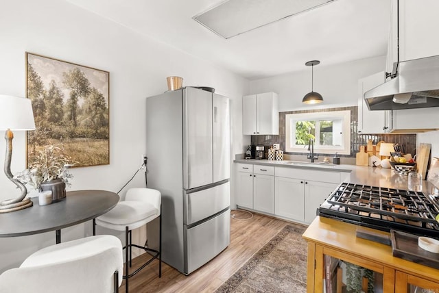 216466 S 40th St, San Diego, CA 92113 - kitchen with freestanding refrigerator, white cabinets, light wood-style floors, light countertops, and decorative backsplash