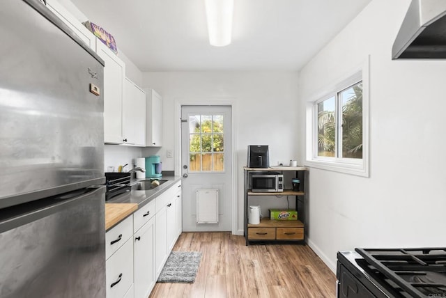 216466 S 40th St, San Diego, CA 92113 - kitchen featuring stainless steel appliances, white cabinets, light wood-type flooring, and butcher block counters